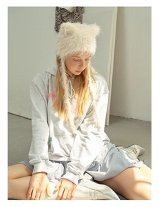 Detailed close-up of fuzzy beige cat ear hat featuring cute plush ears and star accents
