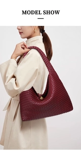Deep red hand-woven leather crescent bag shown on model with premium minimalist texture