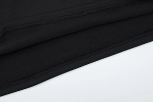 Macro shot of precise overlock stitching on black knit fabric of the backless jumpsuit