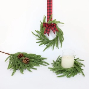 Macro detail of artificial Norfolk pine needles with natural pinecones and bow