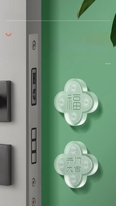 Close-up of a clear silicone bumper guard in clover shape installed on a green wall