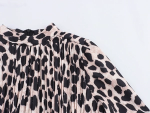Detail of leopard print dress featuring a pleated stand collar and back zipper closure