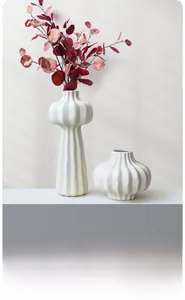 Detail of white matte ceramic vases with vertical ribbed texture in minimalist interior decor