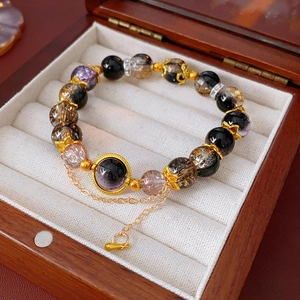 Macro detail of vintage beaded bracelet with mineral stones and gold filigree on white velvet