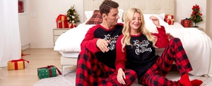 Detail of couple Christmas pajamas featuring Merry Christmas print and red plaid patterns