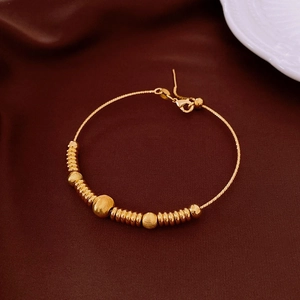 Macro shot of 18k gold plated vintage beaded bracelet on elegant velvet background