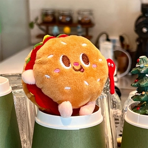 Macro detail of plush burger keychain featuring embroidered face and layered felt ingredients