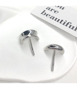Macro shot of silver crescent metal hair clips on a white minimalist stone display
