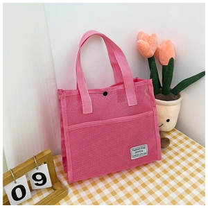 Detail view of pink mesh tote bag featuring white woven label and black snap closure