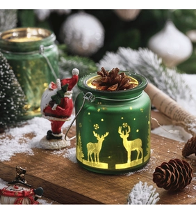 Detail of green frosted glass reindeer candle holder with pine cone and metal handle