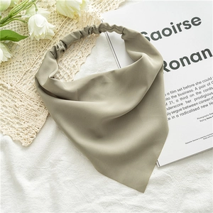 Close-up of light green chiffon hair scarf with elastic band on white texture