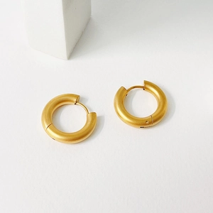 Macro view showing the matte gold finish on these chunky minimalist hoop earrings