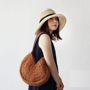 Handwoven straw tote bag with shoulder strap for beach vacation and summer travel