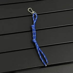 Macro view of blue woven paracord keychain with reflective strips and metal hook