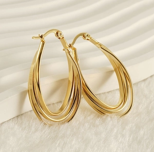 Detail of triple-layered gold-plated oval hoop earrings with a smooth polished finish