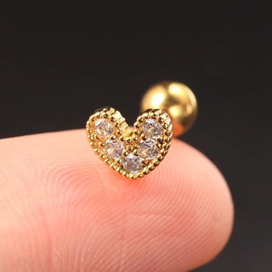 Macro shot of gold heart stud earring with clear zircon and screw back closure
