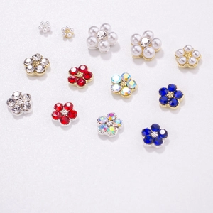 Detailed view of plum blossom nail charms with pearls and colorful rhinestones