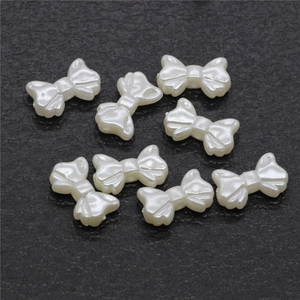 Pearlescent white butterfly resin beads for DIY jewelry making on stone background