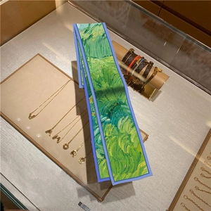 Close-up of narrow oil painting style silk scarf displayed on a jewelry tray