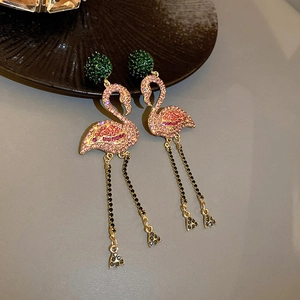 Detailed close-up of flamingo-shaped rhinestone earrings with elegant long tassel chains