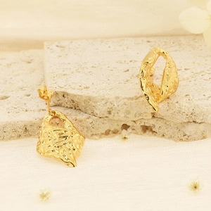 Boucles d'oreilles vintage en or avec texture plissée et perle sur un socle en pierre