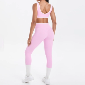 Detailansicht der Rückseite eines rosa Yoga-Sets mit weißen Kontraststreifen und Kreuzträgern