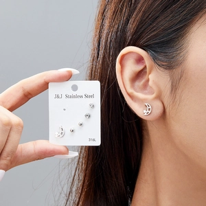 Detail of 316L stainless steel moon and star stud earrings set with crystal stones