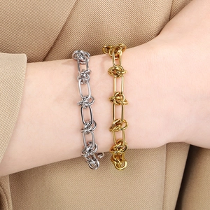 Nahaufnahme von goldenen und silbernen Punk-Armbändern mit Knotenmuster aus Edelstahl
