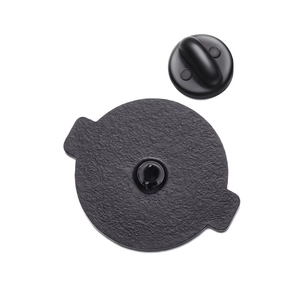 Détail de l'arrière du badge en émail noir avec fermoir en caoutchouc et métal texturé