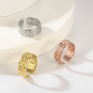 Dettaglio della trama intrecciata degli anelli regolabili oro, argento e oro rosa