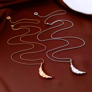 Macro shot of gold and silver croissant moon pendant necklaces on red silk background