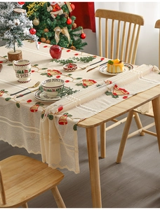 Christmas table runner with red bell embroidery and lace on a wooden dining table