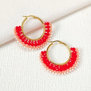 Detailed macro view of handmade watermelon-shaped seed bead earrings with gold hoops