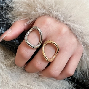 Detail of irregular geometric open rings in gold and silver finish for a trendy look
