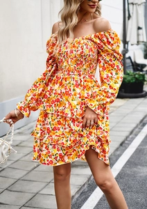 Detail view of colorful floral dress with off-shoulder design and ruffled hemline