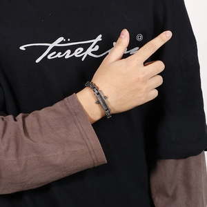 Detail of retro stainless steel cross bar chain bracelet worn on a male wrist
