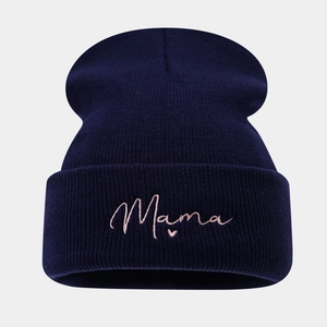 Detailopname van Mama-borduurwerk en hartje op de donkerblauwe gebreide beanie