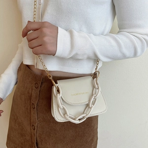 Mini cream white crossbody bag with gold chain strap and chunky resin handle on model