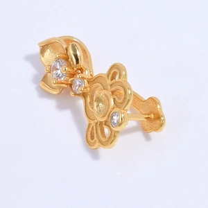 Detailed close-up of golden hollow flower charm with three inlaid zircons for jewelry making