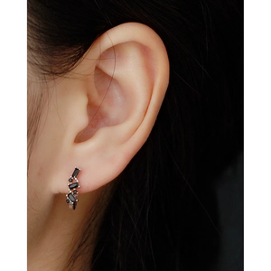 Detailed close-up of S925 sterling silver U-shaped earring with black zircon on ear