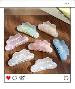 Macro detail of seven iridescent cloud-shaped hair claws in assorted pastel colors