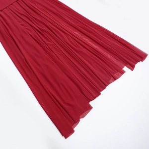 Gros plan détaillé du tissu en maille rouge plissé montrant la texture légère du mousseline