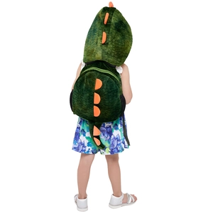 Detail of plush green dinosaur backpack for kids with orange fins and soft texture