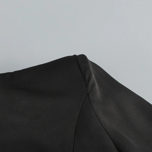 Detail der Schulternaht und Webstruktur eines schwarzen Paillettenkleides