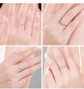 Macro detail of S925 sterling silver chain rings with heart, star, and infinity charms