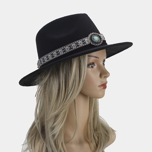 Detalle de un sombrero fedora negro con cinta étnica tejida y hebilla metálica turquesa