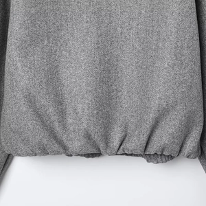 Close-up of gray bomber jacket ribbed hem and premium textured wool-like fabric