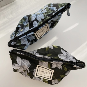 Floral jacquard fabric pouch with zipper and Pleasant Time label in blue and white patterns