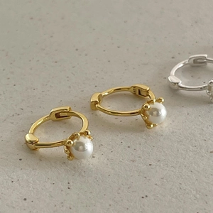 Close-up of S925 sterling silver hallmark on pearl hoop earrings with gold finish