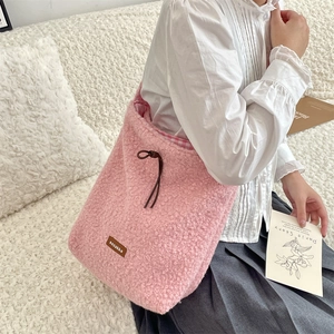 Detalle de bolso bandolera de felpa rosa con cordón de cuero y forro tejido